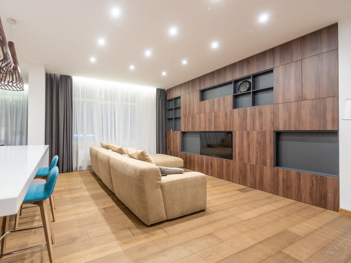 Plafond de salon équipé de spots encastrés allumés au-dessus d'un parquet chêne