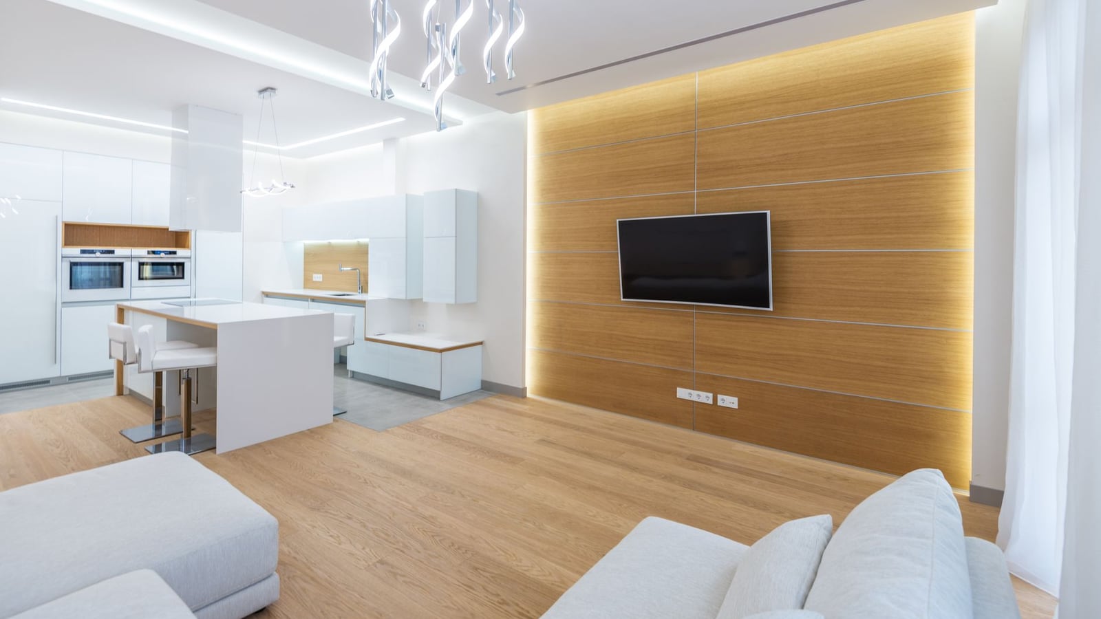 Salon moderne mis en lumière par un mur en bois rétroéclairé et des suspensions